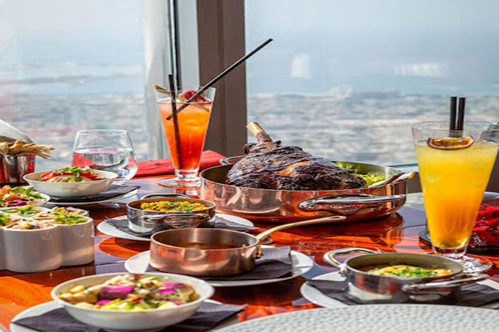 بشقاب غذای لوکس سرو شده در رستوران At.mosphere با منظره شبانه شهر دبی از طبقه ۱۲۲ برج خلیفه