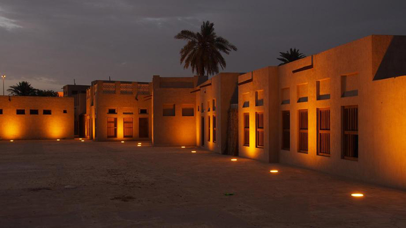 نمای بیرونی خانه شیخ سعید آل مکتوم با بادگیرهای سنتی و دیوارهای مرجانی در کنار خور دبی