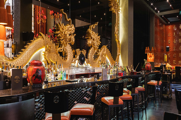 تصویری از فضای داخلی Buddha-Bar Dubai با مجسمه بودا، نورپردازی ملایم و میزهای شام لوکس در هتل Grosvenor House